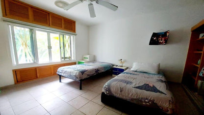 una recamara con 2 camas y una ventana grande en condo kin be playa del carmen