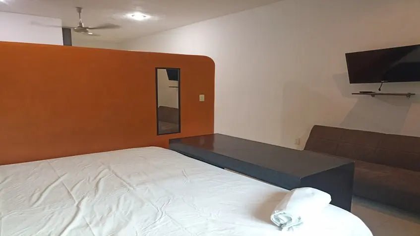 una recamara principal con un sofa cama en xharm condo playa del carmen