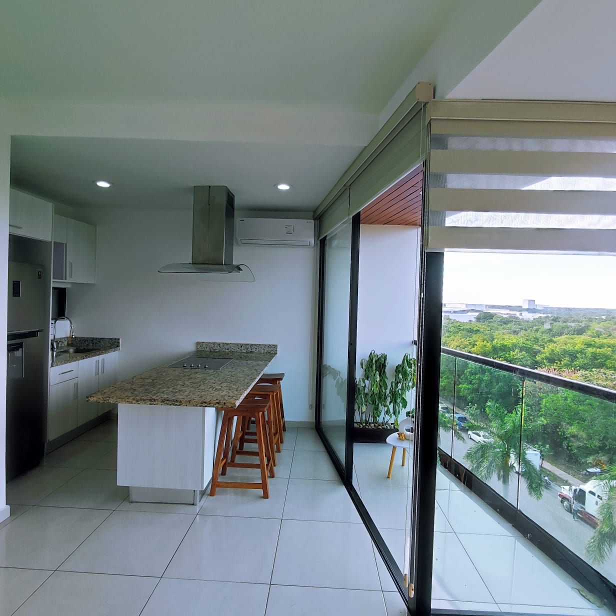 una cocina integral con barra de granito y una barra desayunadora en playa aurora playa del carmen