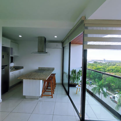 una cocina integral con barra de granito y una barra desayunadora en playa aurora playa del carmen