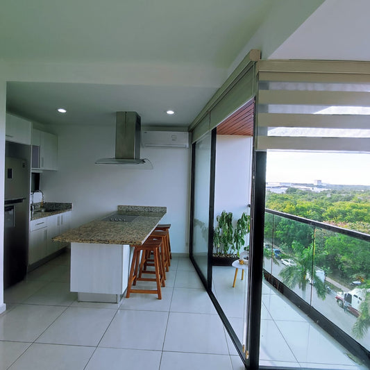 una cocina integral con barra de granito y una barra desayunadora en playa aurora playa del carmen