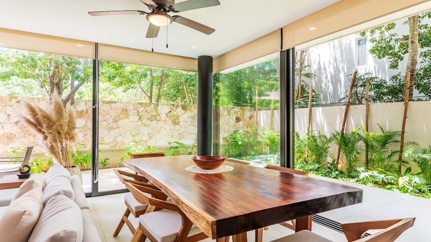 una sala y un comedor con vista al jardin en mak tulum