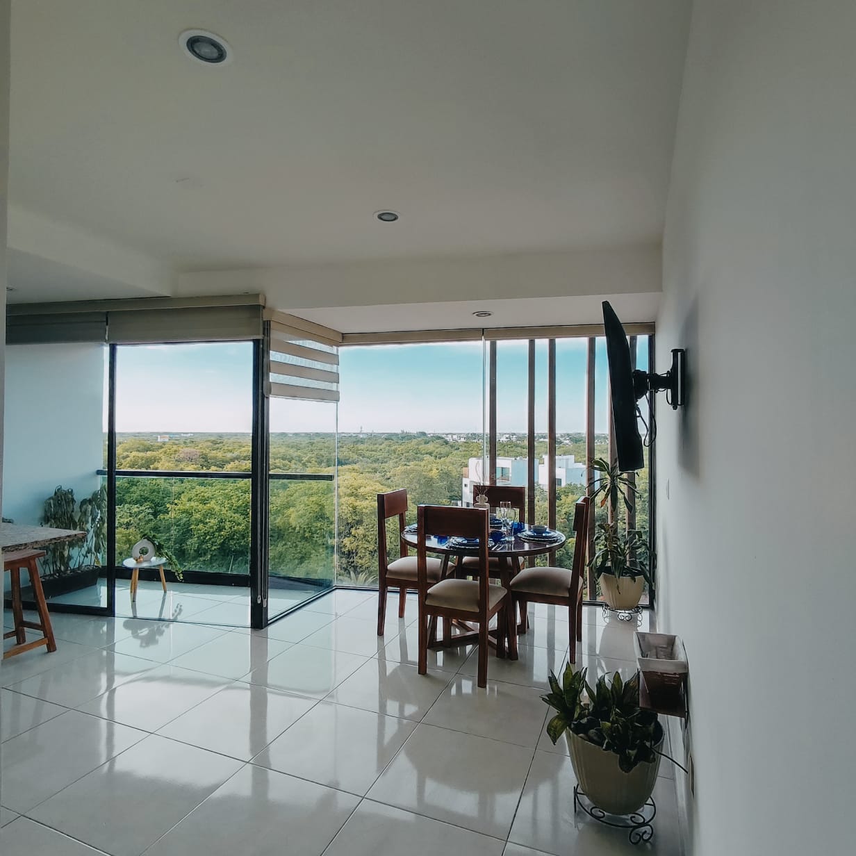 un comedor con vista a las areas verdes y a la ciudad en playa aurora playa del carmen