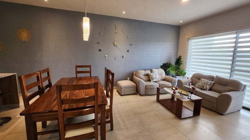 una sala y un comedor con un sofa en selvanova coto 8 playa del carmen