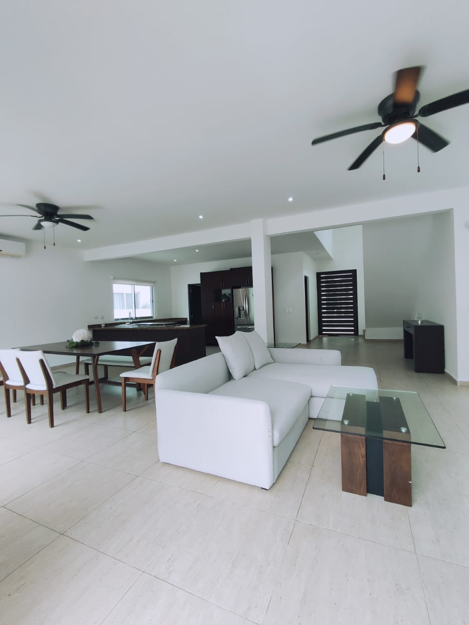 una estancia grande con un comedor y una cocina al fondo en residencial playa magna playa del carmen