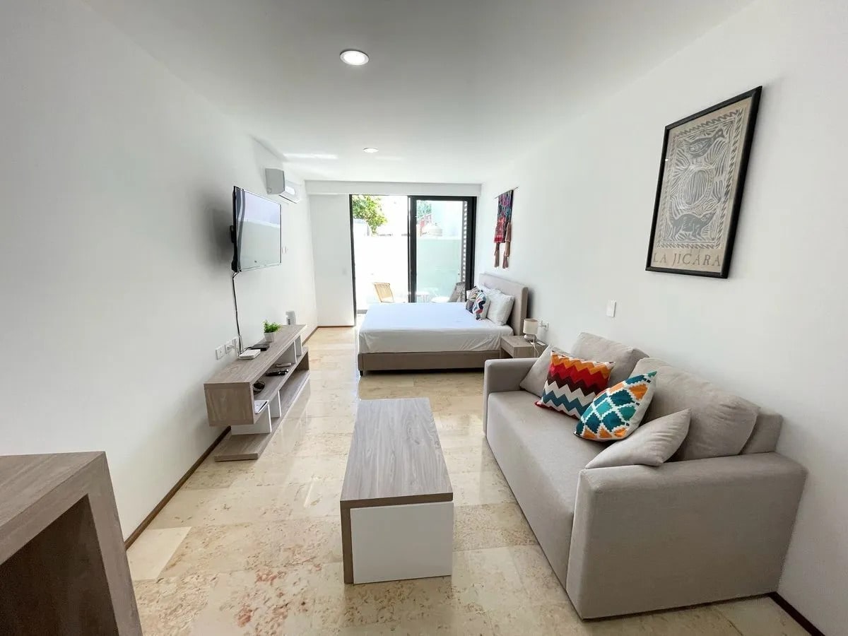 una sala, una tv y un sofa cama en a perfect place playa del carmen