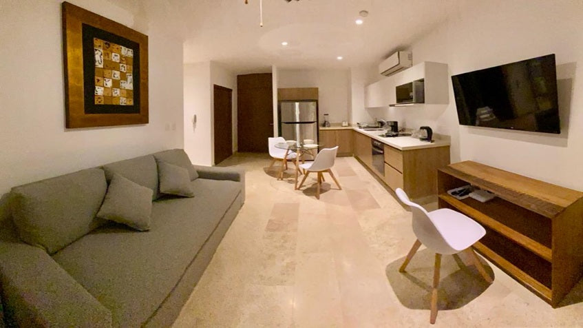 una sala, una tv y un comedor chico en ipana condos playa del carmen