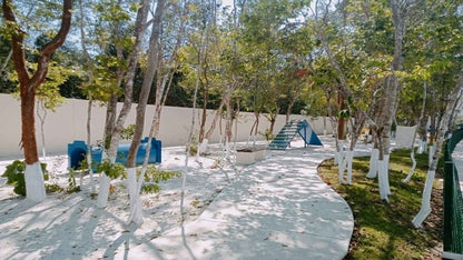 un parque infantil con areas verdes en la selva residences playa del carmen