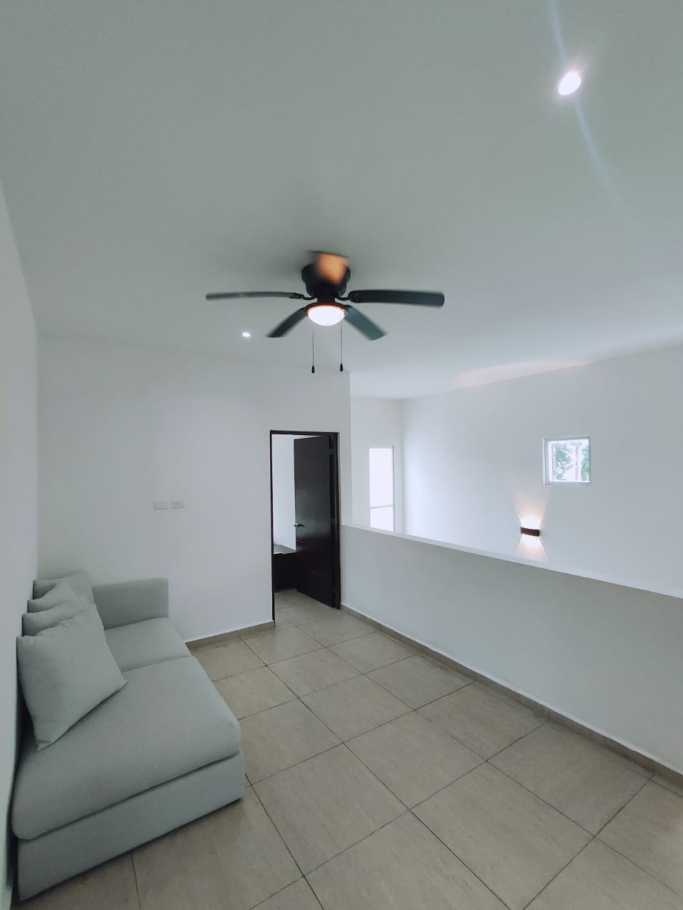 un sofa con un ventilador y un pasillo en residencial playa magna playa del carmen