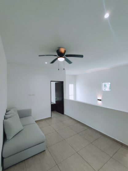 un sofa con un ventilador y un pasillo en residencial playa magna playa del carmen