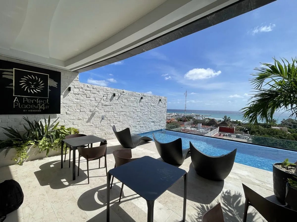 una terraza con alberca y vista al mar en a perfect place playa del carmen