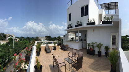 una terraza con sillas y camastros en xharm condo playa del carmen