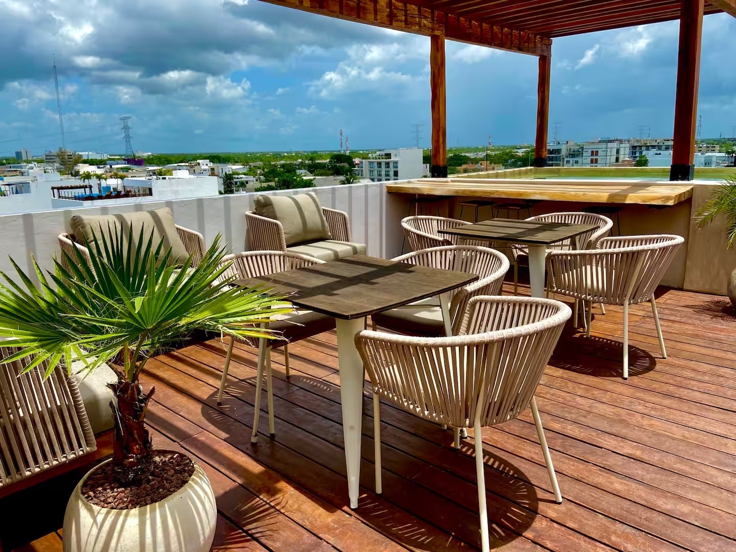 un area de terraza con alberca y sillas para comer en tzalam residences playa del carmen