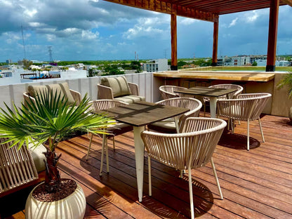 un area de terraza con alberca y sillas para comer en tzalam residences playa del carmen
