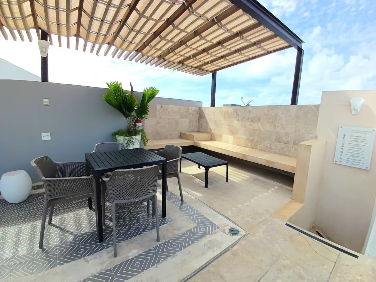 una terraza al aire libre con un pergolado en menesse on the beach playa del carmen