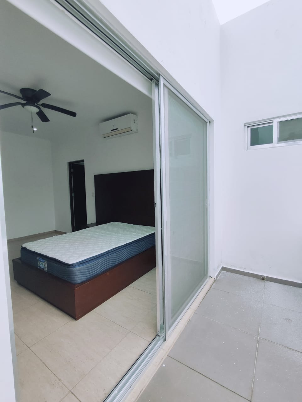 una cama matrimonial con un ventilador en residencial playa magna playa del carmen