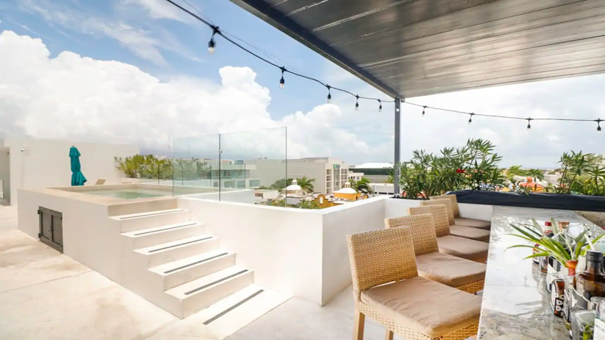 una terraza comun con un area de bar en anah condos playa del carmen