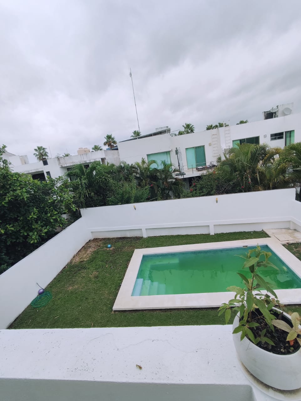 una piscina con un jardin grande vista desde lo alto en residencial playa magna playa del carmen