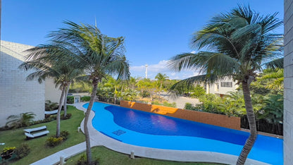 una alberca vista desde arriba con palmeras alrededor y jardines en marina mia puerto aventuras