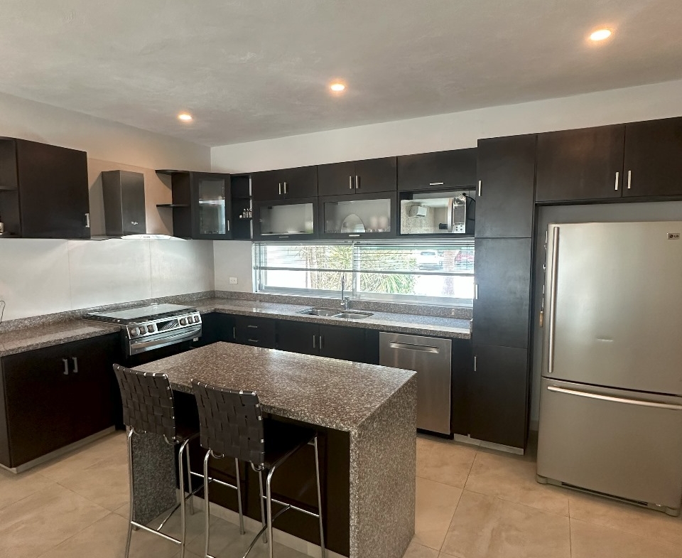 una cocina equipada con una estufa, un refrigerador y una isla en playa magna playa del carmen