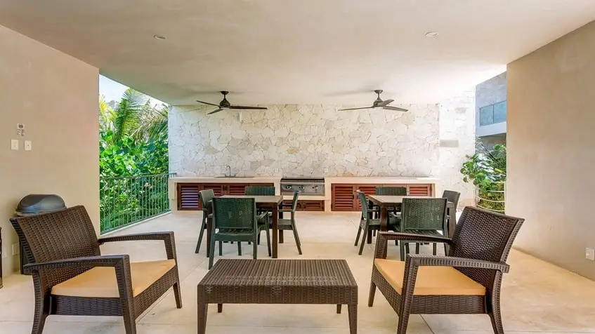 un area de asadores con una mesa grande y sillas en Santamar Akumal