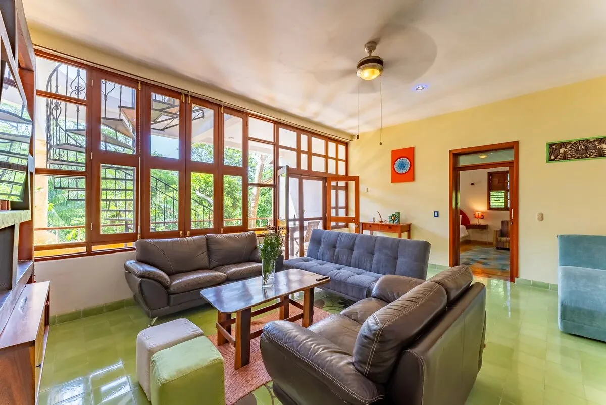 un area de sofa con un ventilador y bien iluminado en xcaret playa del carmen