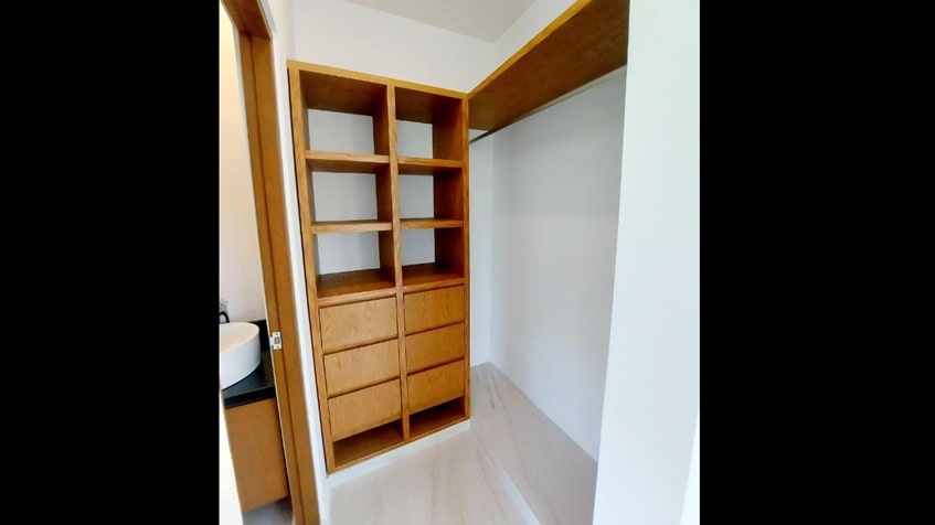 un closet de madera y un baño completo en fraccionamiento playa magna