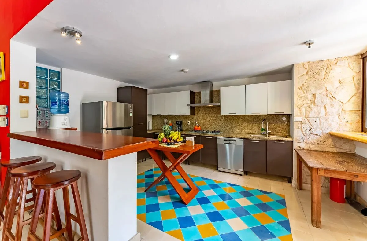 una cocina, un refrigerador y unos closets de madera para cocina en xcaret playa del carmen