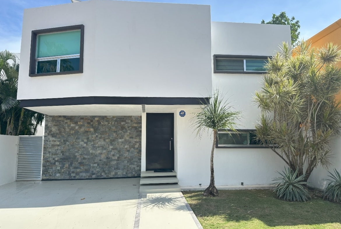 una fachada exterior de una casa grande con areas verdes en playa magna playa del carmen