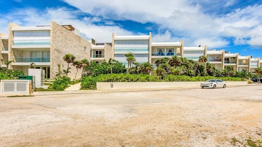 una fachada con varios departamentos alrededor y areas verdes en Santamar Akumal