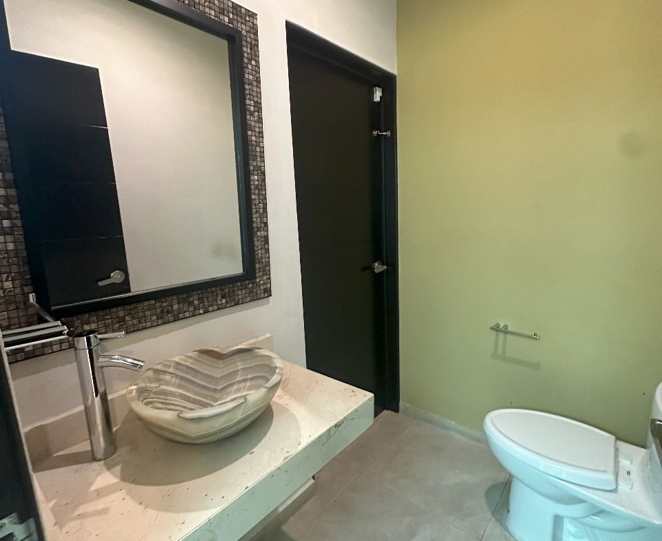 un baño con un lavamanos y un espejo grande en playa magna playa del carmen