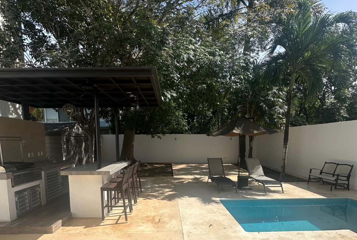 un area de asasdores con una alberca privada en playa magna playa del carmen