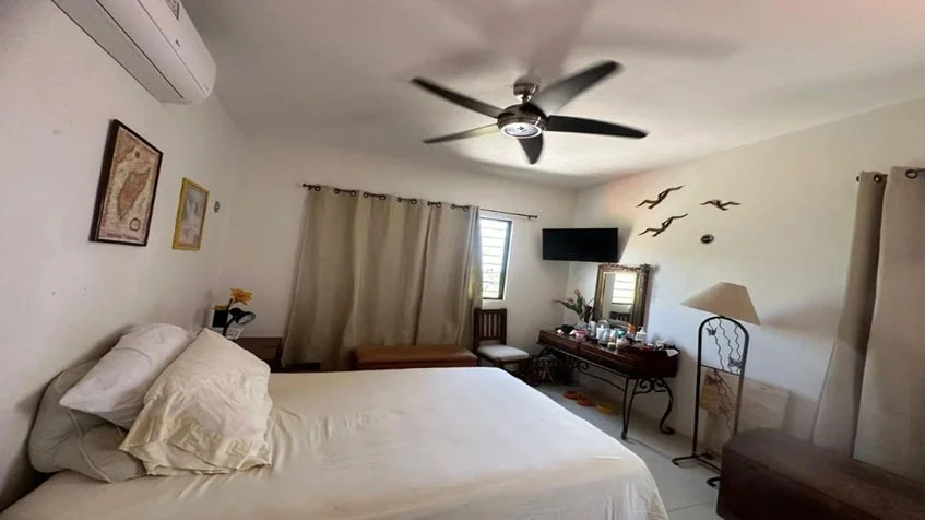una recamara numero tres con un buro de madera, un ventilador y un aire acondicionado en cataluña playa del carmen