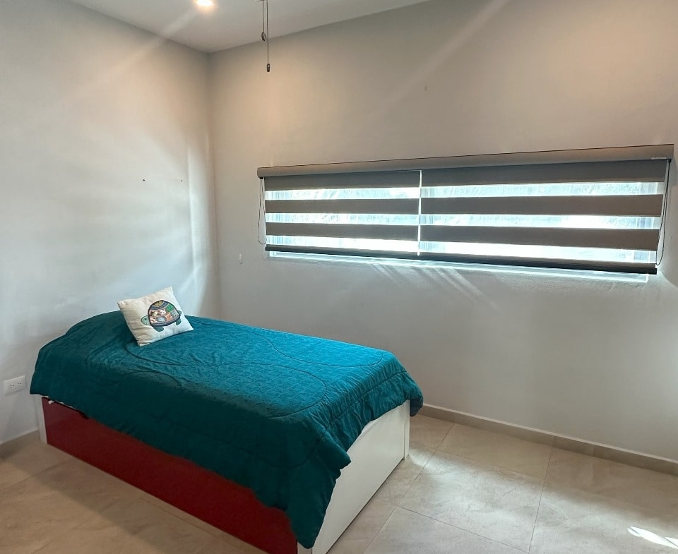 una recamara con persianas en playa magna playa del carmen