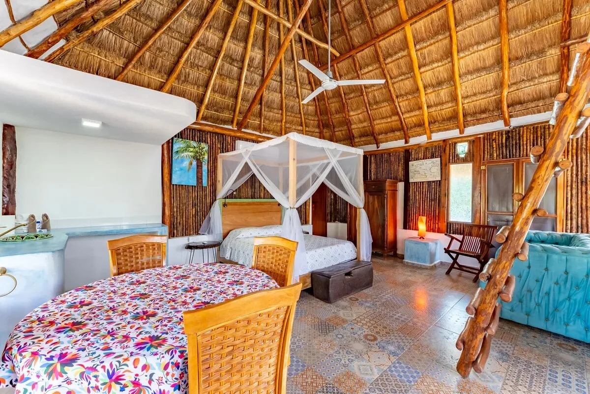 un area de sala con una palapa y un ventilador en xcaret playa del carmen