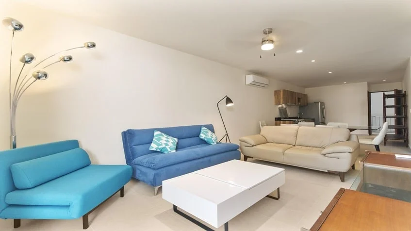 una sala elegante,un sofa y una cocina atras en Santamar Akumal