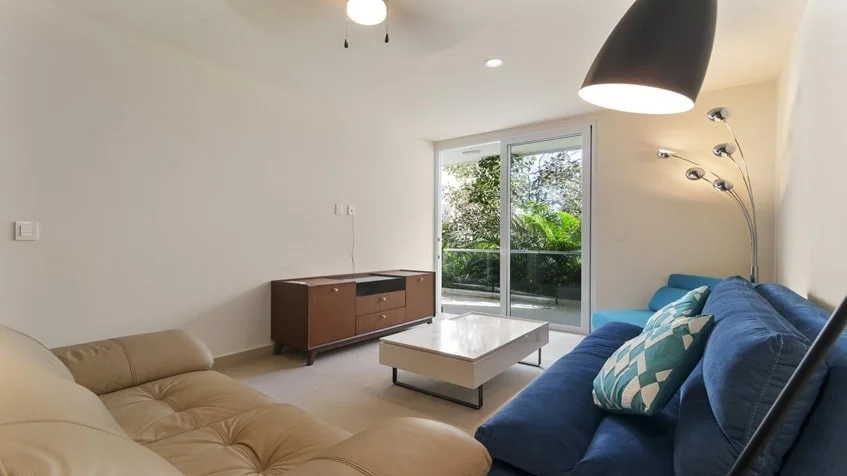 un espacio con sala y un balcon con vista al jardin en Santamar Akumal