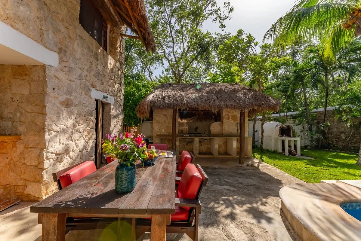 un area de terraza grande, un horno de piedra y un bar estilo maya en xcaret playa del carmen