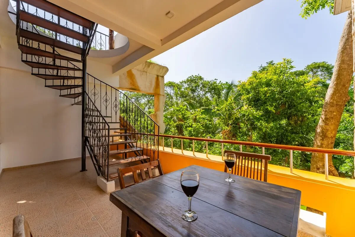una terraza con una mesa de madera con vista al jardin en xcaret playa del carmen