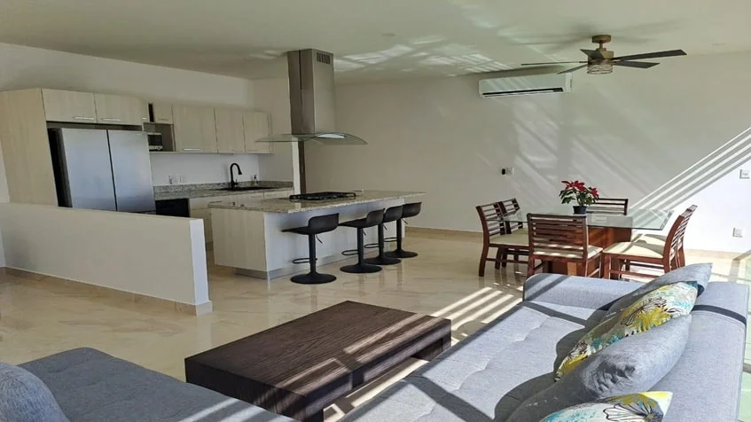 una cocina integral de lujo con una mesa de granito y una campana extractora en valle aurora playa del carmen