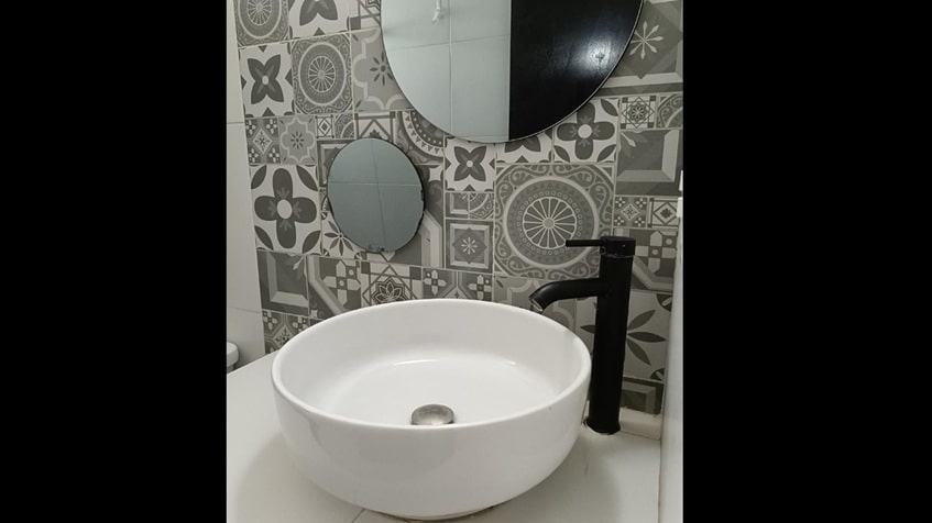 un lavamanos con un espejo circular en santa fe del carmen