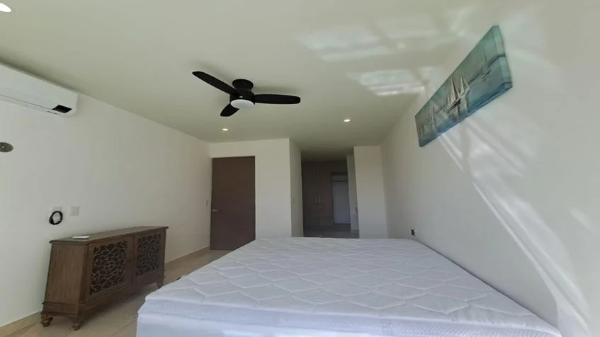 una recamara con aire acondicionado y un ventilador de techo en valle aurora playa del carmen