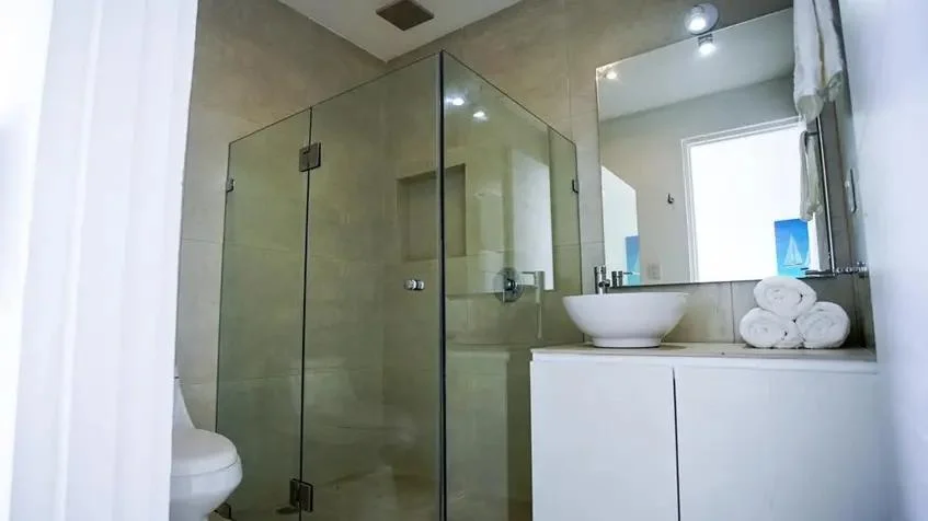 un baño completo con un espejo y una ducha en bianco sea view playa del carmen
