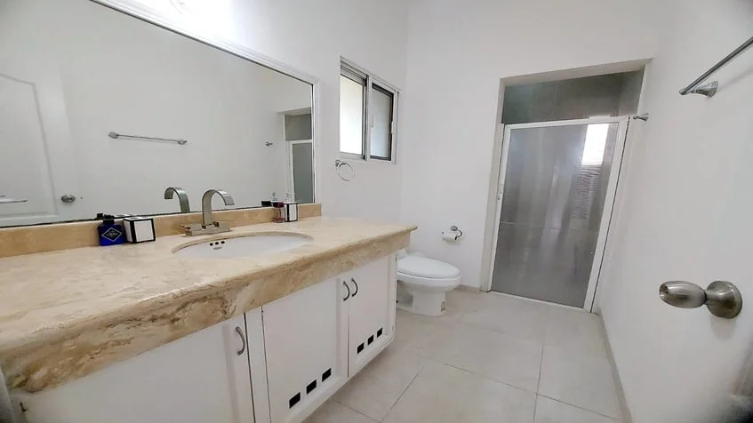 un baño con un espejo grande en condominio bugambilias playa del carmen