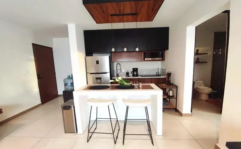 una cocina equipada y una barra desayunadora elegante en mya black diamond playa del carmen
