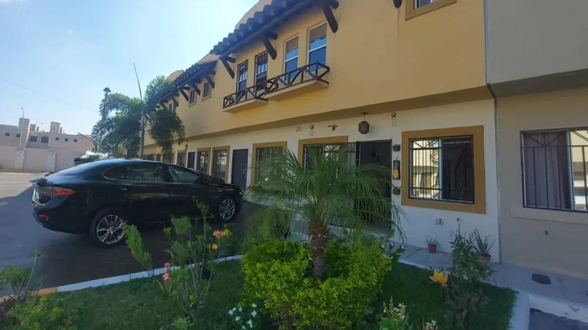una fachada de una casa con un auto de lujo estacionado en real amalfi playa del carmen