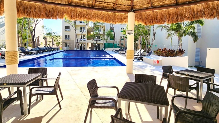 una alberca con una palapa para eventos en la selva residences playa del carmen