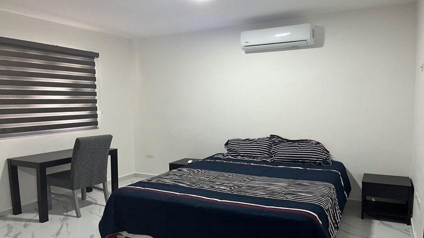 una recamara con un escritorio en la selva residences playa del carmen