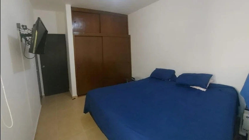 una recamara principal con una tv y un closet grande de madera en real amalfi playa del carmen