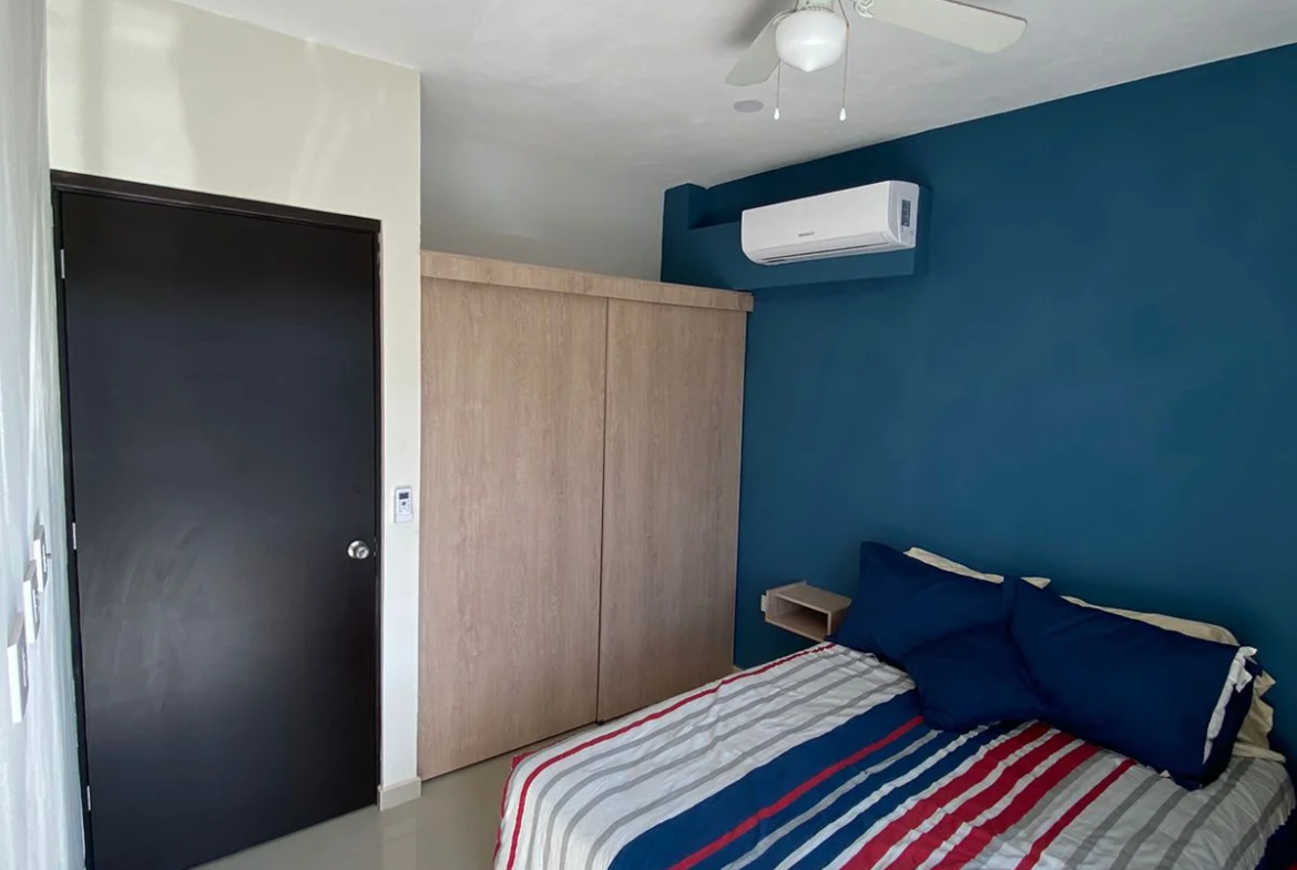 una recamara con cama matrimonial y closets en yaakun condos playa del carmen